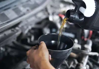 a person pouring oil into a black cup