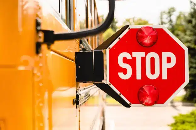 Prepare your vehicle for back to school traffic with Firestone of Durango in Durnago, CO. Image of a yellow school bus stop sign.