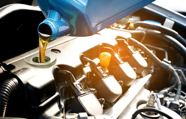 : The benefits of a fall oil change in Durango, CO. with Firestone of Durango. Image of new oil being poured into the car engine while in the shop for an oil change.