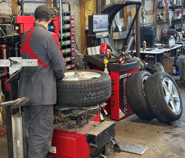 Benefits of seasonal tire rotation in Durango, CO with Firestone of Durango. Image of one of our mechanics using the tire rotation machine in the shop while performing tire services.