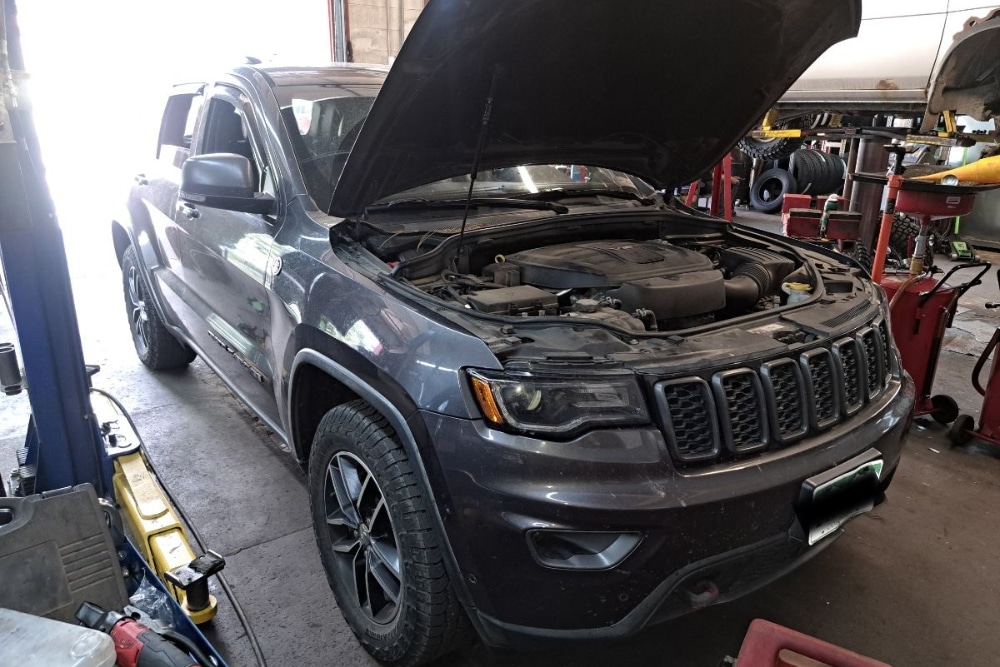 Finance Your Auto Repairs in Durango, CO At Firestone of Durango. Vehicle with open hood inside an auto repair shop.