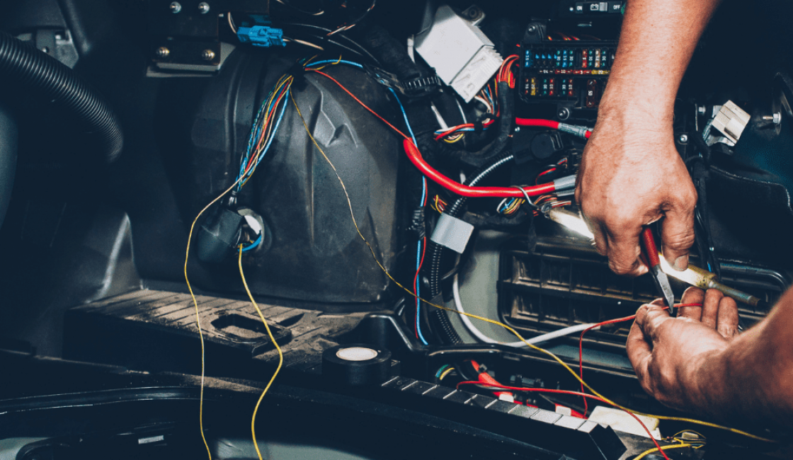 car electrical repair, auto repair in Durango, CO at Firestone of Durango. Hands working on car wiring with various colorful wires and components, highlighting intricate auto electrical repair.