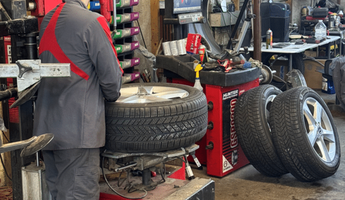 Benefits of seasonal tire rotation in Durango, CO with Firestone of Durango. Image of one of our mechanics using the tire rotation machine in the shop while performing tire services.